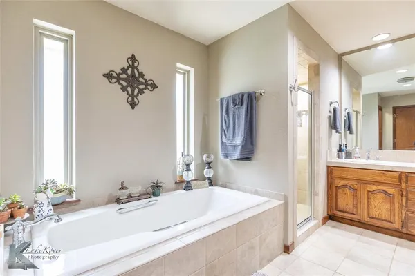 a bathroom with a tub sink and mirror