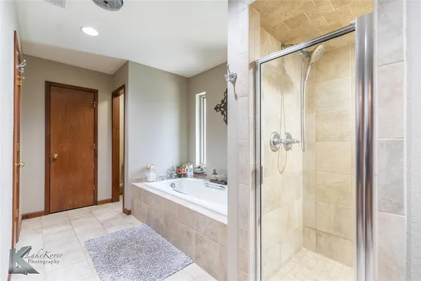 a bathroom with a tub shower and sink