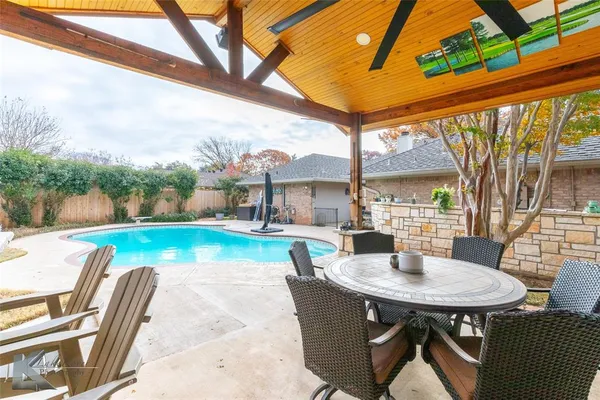 a view of backyard with swimming pool and patio