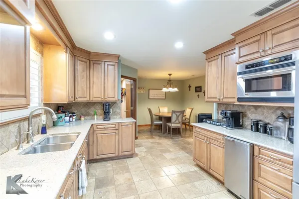 a kitchen with stainless steel appliances a sink a stove and cabinets
