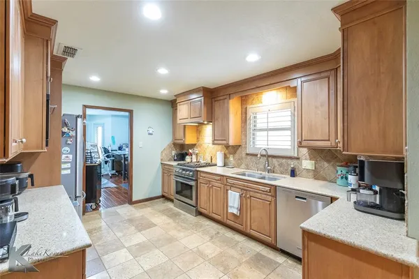 a kitchen with a sink stove and cabinets