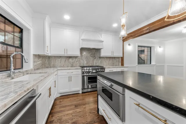 a kitchen with stainless steel appliances granite countertop a stove a sink and a granite counter tops
