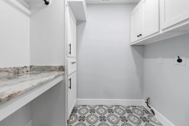 a bathroom with a granite countertop sink and white cabinets