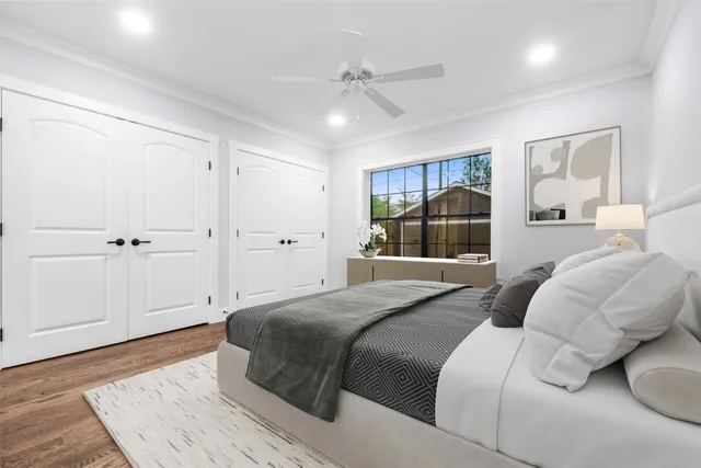 a bedroom with a large bed and wooden floor