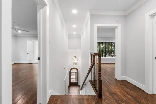 a view of a hallway with wooden floor and furniture