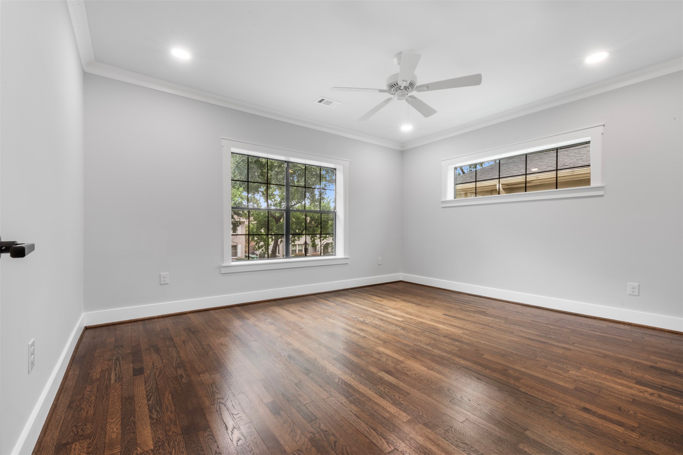 1723 Albans Road Houston, TX 77005 - Photo 33 of 50 an empty room with wooden floor chandelier fan and windows