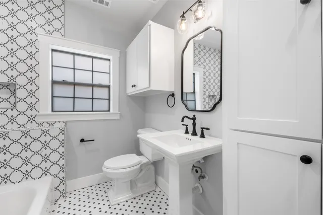 a bathroom with a toilet sink and mirror