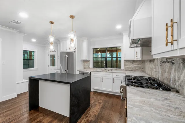 a kitchen with stainless steel appliances granite countertop a sink stove and refrigerator