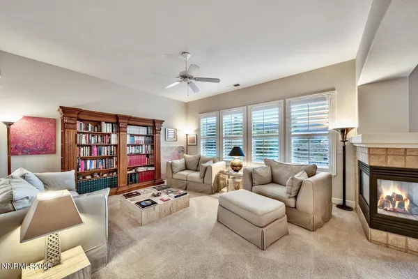 a living room with furniture fireplace and a large window