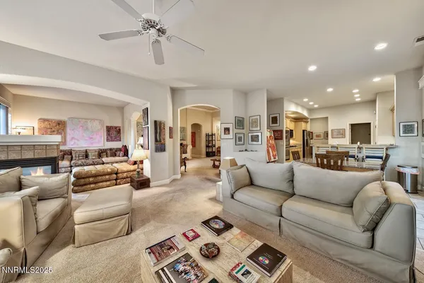 a living room with furniture kitchen view and a chandelier