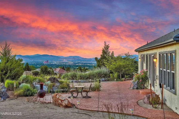 a view of a patio with table and chairs under an umbrella