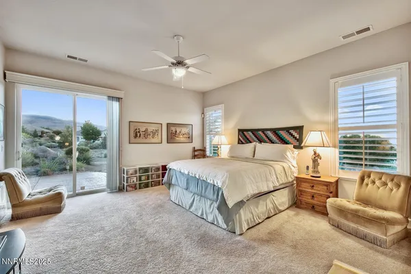 a spacious bedroom with a bed a couch and a window