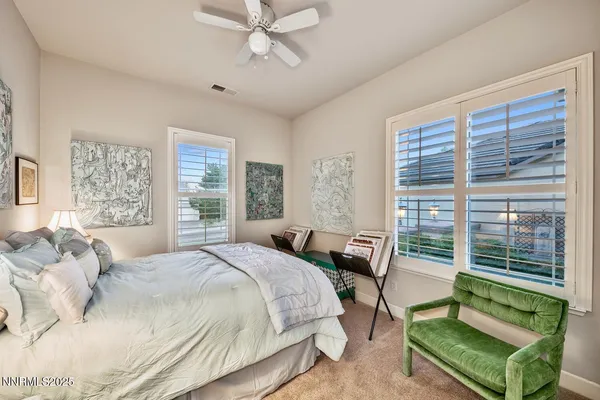 a bedroom with a bed a large window and a chandelier