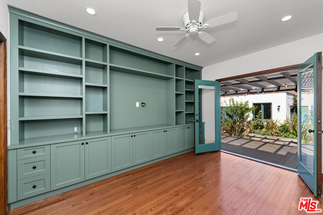 1039 Hi Point Street Los Angeles, CA 90035 - Photo 14 of 27 a view of an empty room with a fireplace and wooden floor
