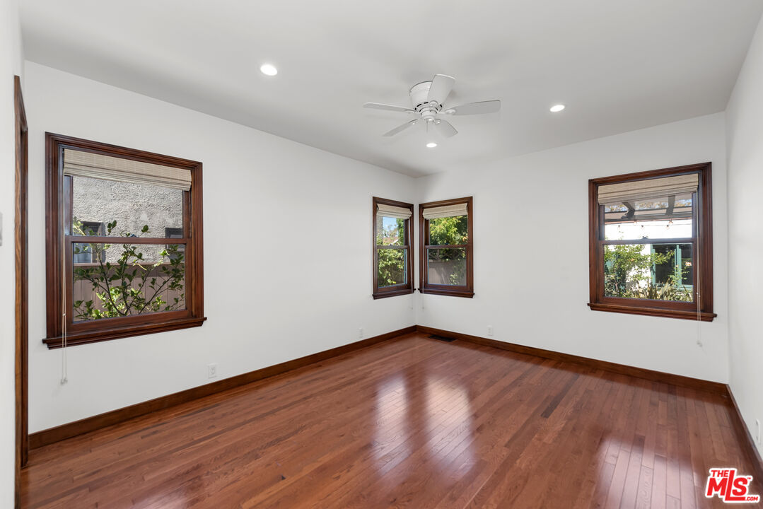 1039 Hi Point Street Los Angeles, CA 90035 - Photo 15 of 27 a view of an empty room with wooden floor and a window
