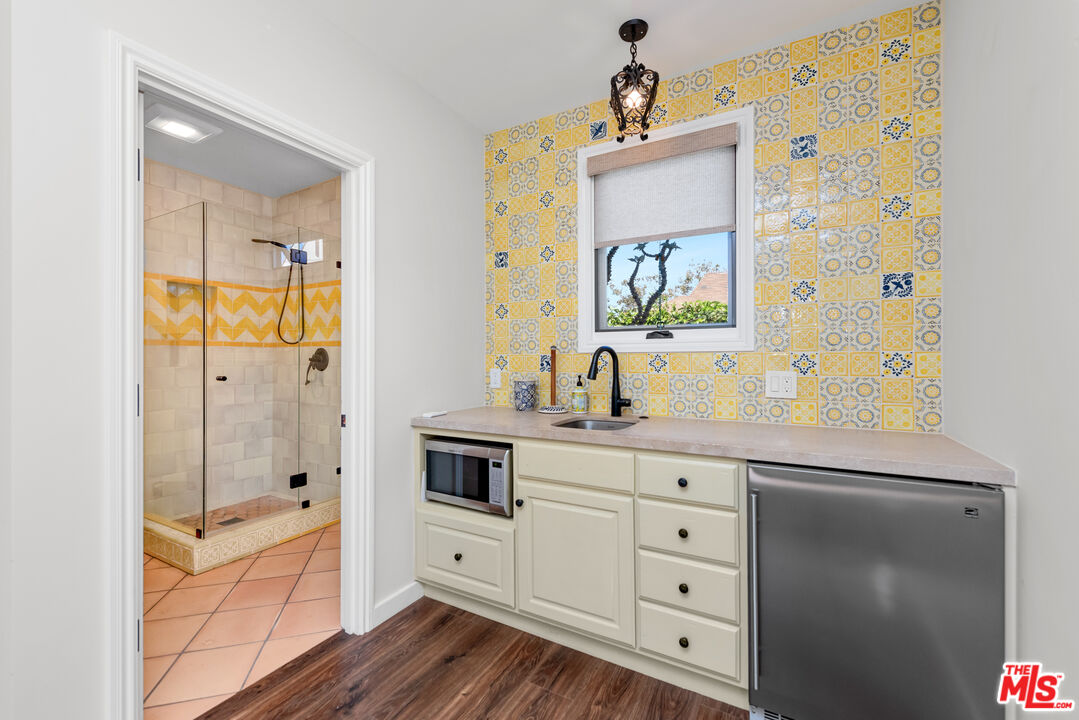 1039 Hi Point Street Los Angeles, CA 90035 - Photo 25 of 27 a spacious bathroom with a granite countertop sink a mirror a shower and a bathtub