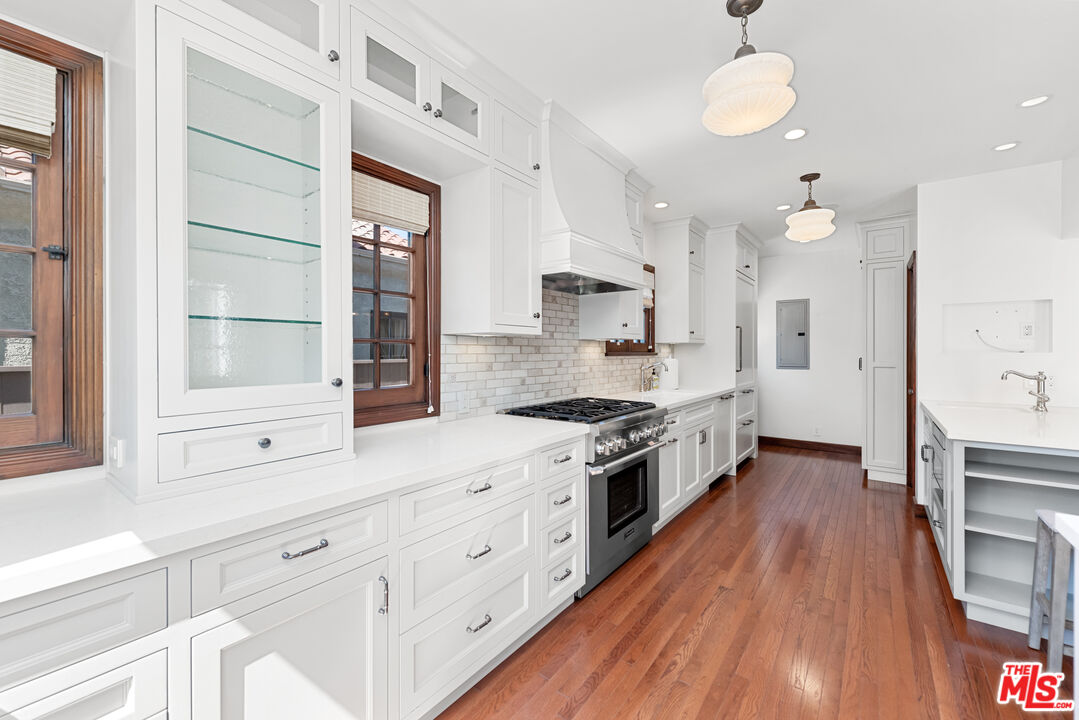 1039 Hi Point Street Los Angeles, CA 90035 - Photo 8 of 27 a large kitchen with cabinets wooden floor and stainless steel appliances