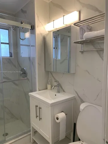 a bathroom with a sink mirror and toilet