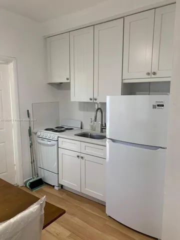 a kitchen with granite countertop cabinets and white appliances