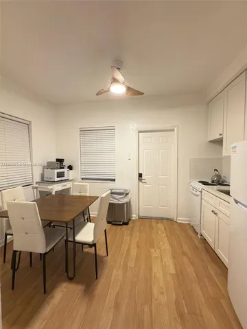 a dining room with a table chairs and a kitchen view