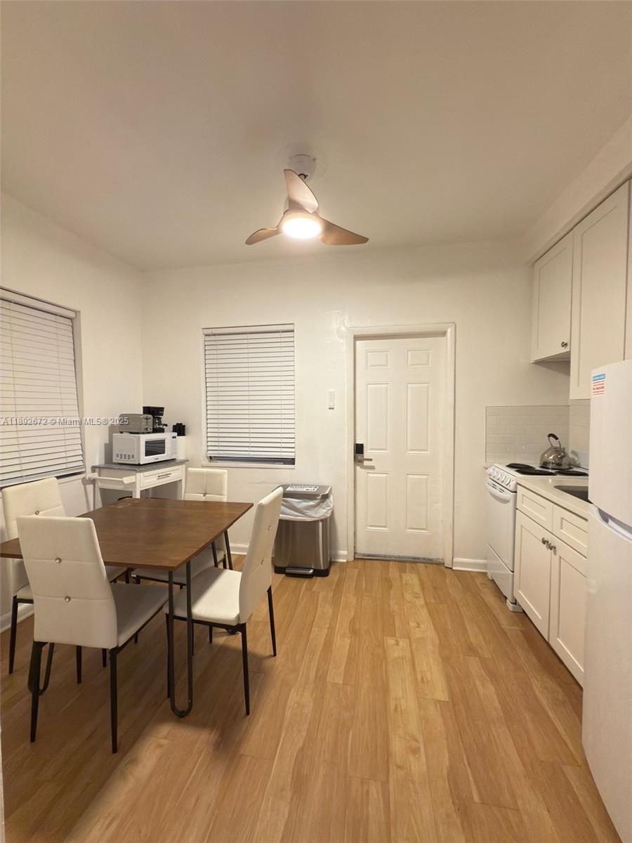 545 Michigan Avenue, Unit 6 Miami Beach, FL 33139 - Photo 6 of 13 a dining room with a table chairs and a kitchen view