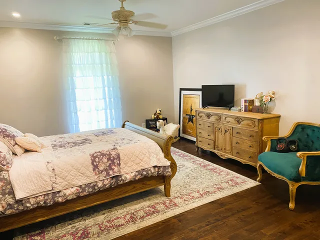 a spacious bedroom with a bed and a flat screen tv