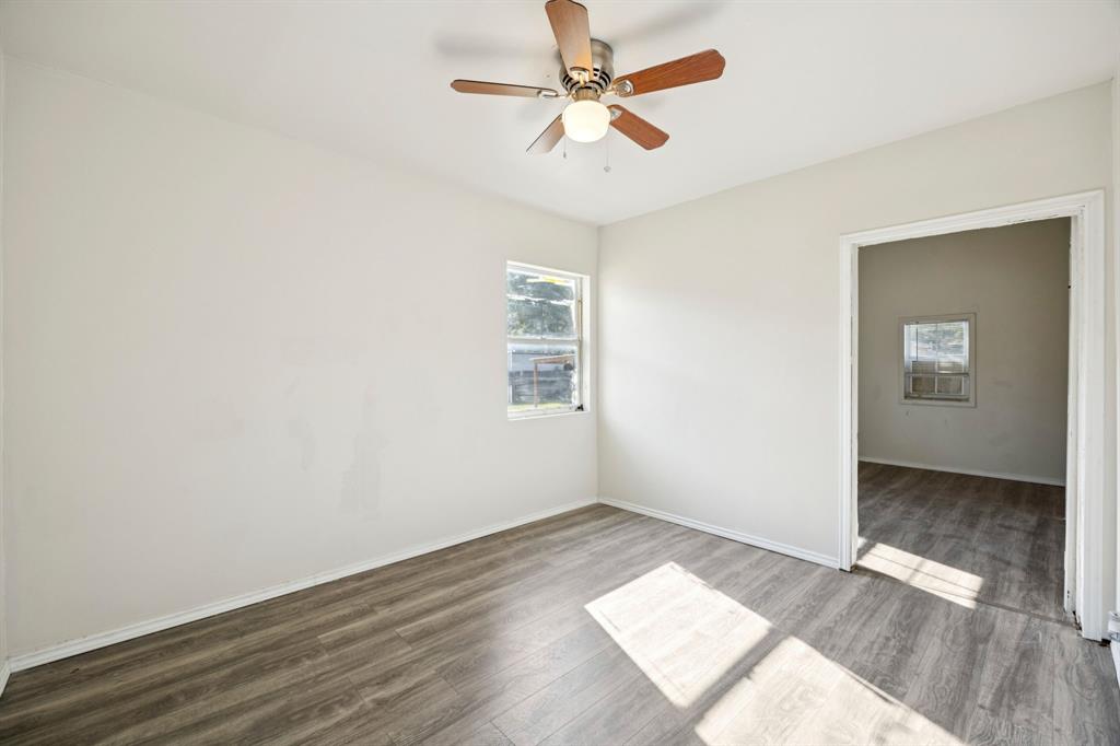 3228 Emmett Street Dallas, TX 75211 - Photo 15 of 25 an empty room with wooden floor chandelier fan and windows