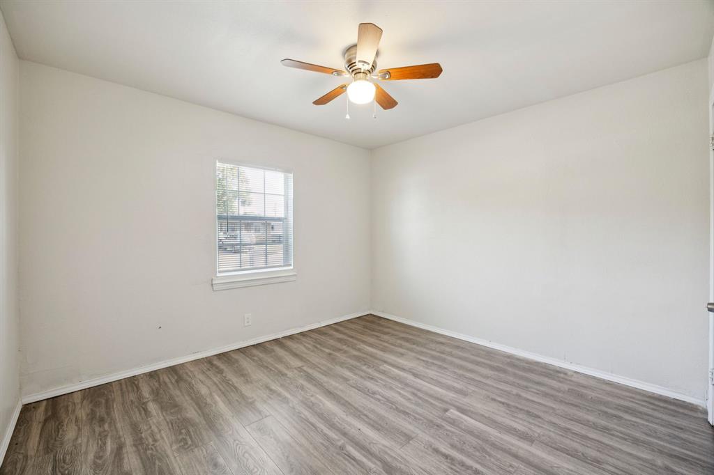 3228 Emmett Street Dallas, TX 75211 - Photo 16 of 25 wooden floor in an empty room with a window