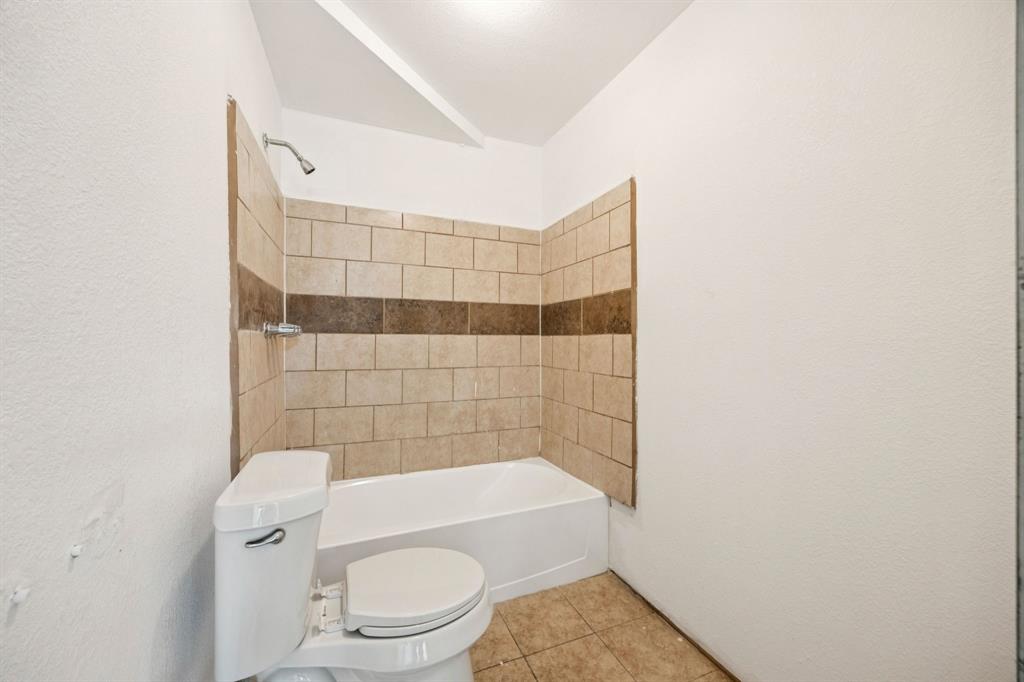 3228 Emmett Street Dallas, TX 75211 - Photo 17 of 25 a bathroom with a toilet and a bathtub