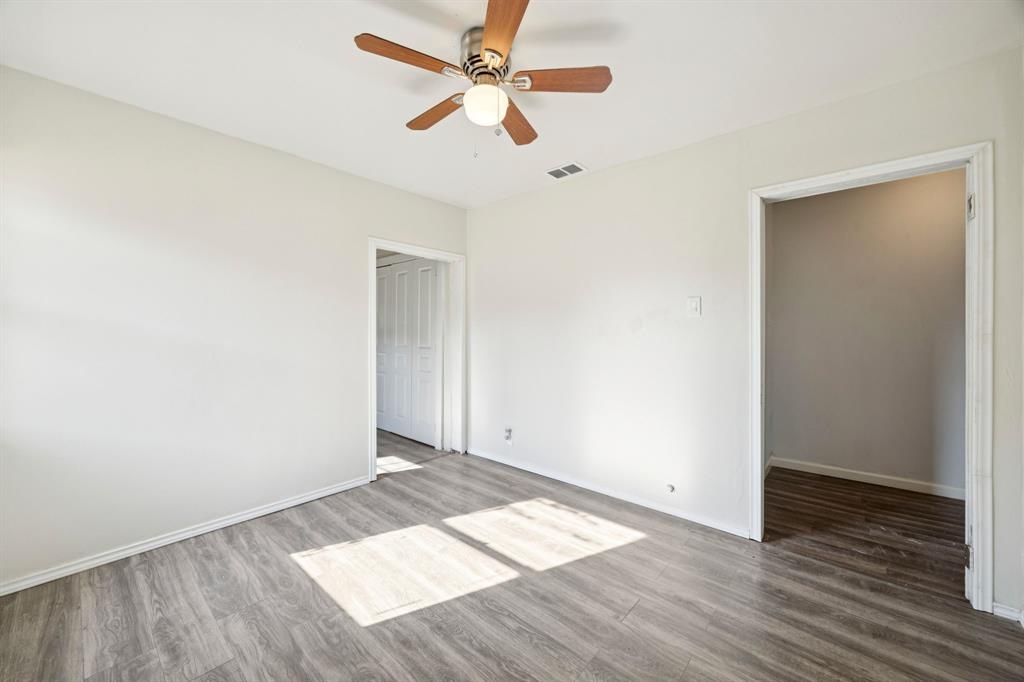 3228 Emmett Street Dallas, TX 75211 - Photo 18 of 25 an empty room with wooden floor ceiling fan and window