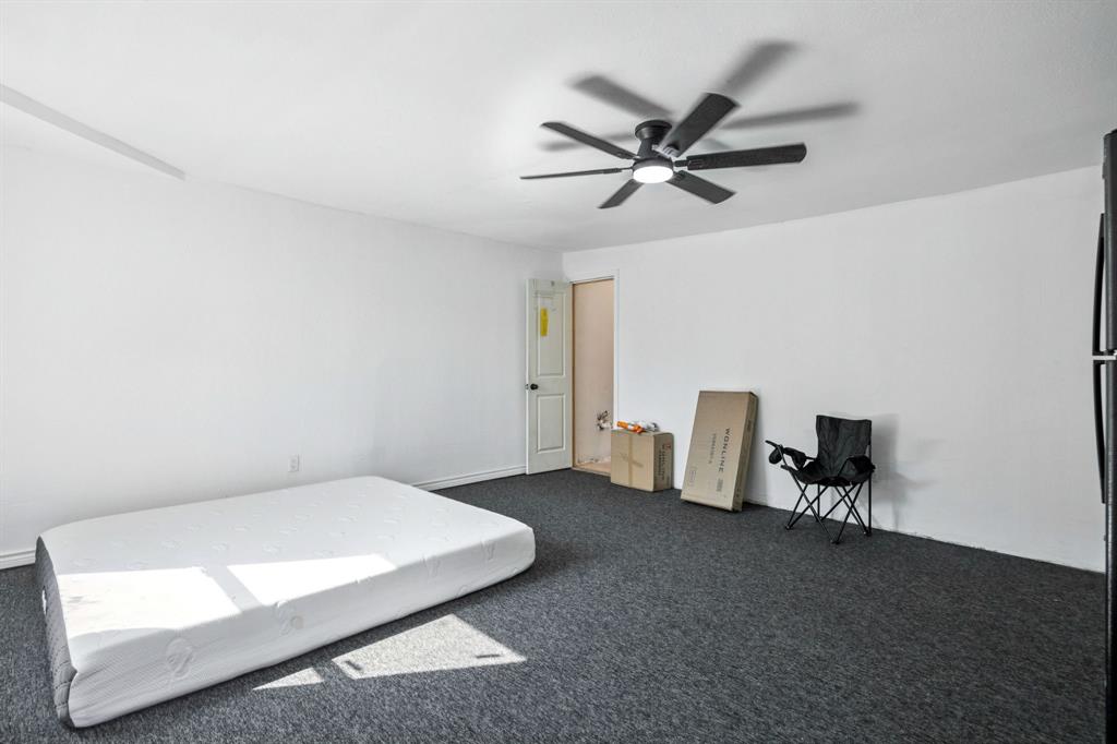 3228 Emmett Street Dallas, TX 75211 - Photo 20 of 25 a bedroom with a bed and chair