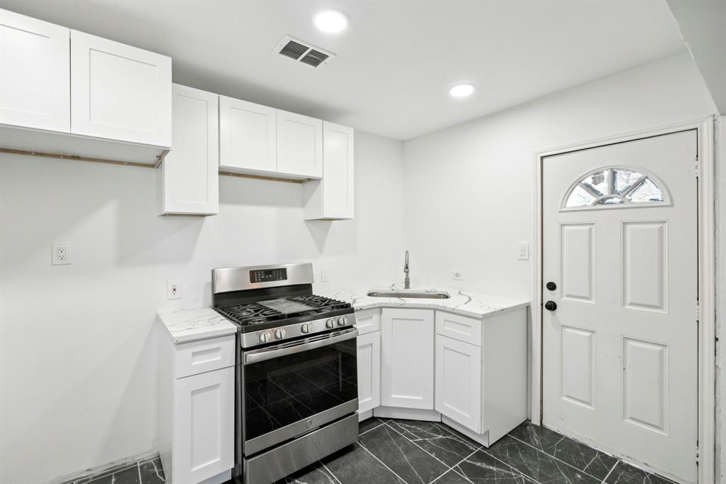 3228 Emmett Street Dallas, TX 75211 - Photo 8 of 25 a kitchen with granite countertop white cabinets and white appliances