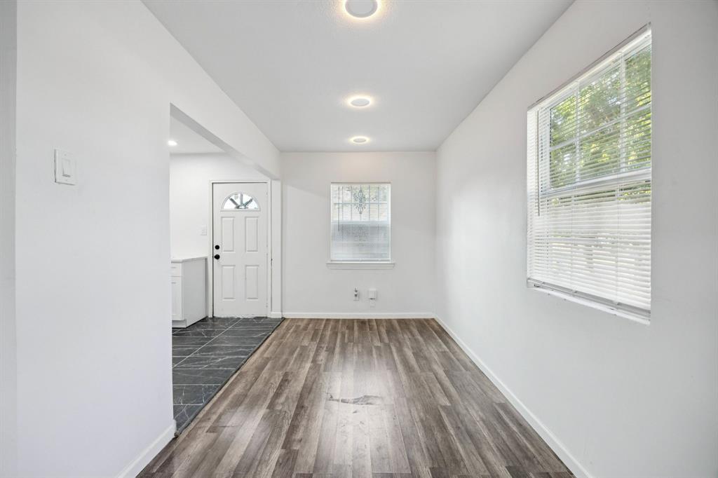 3228 Emmett Street Dallas, TX 75211 - Photo 9 of 25 an empty room with wooden floor and windows