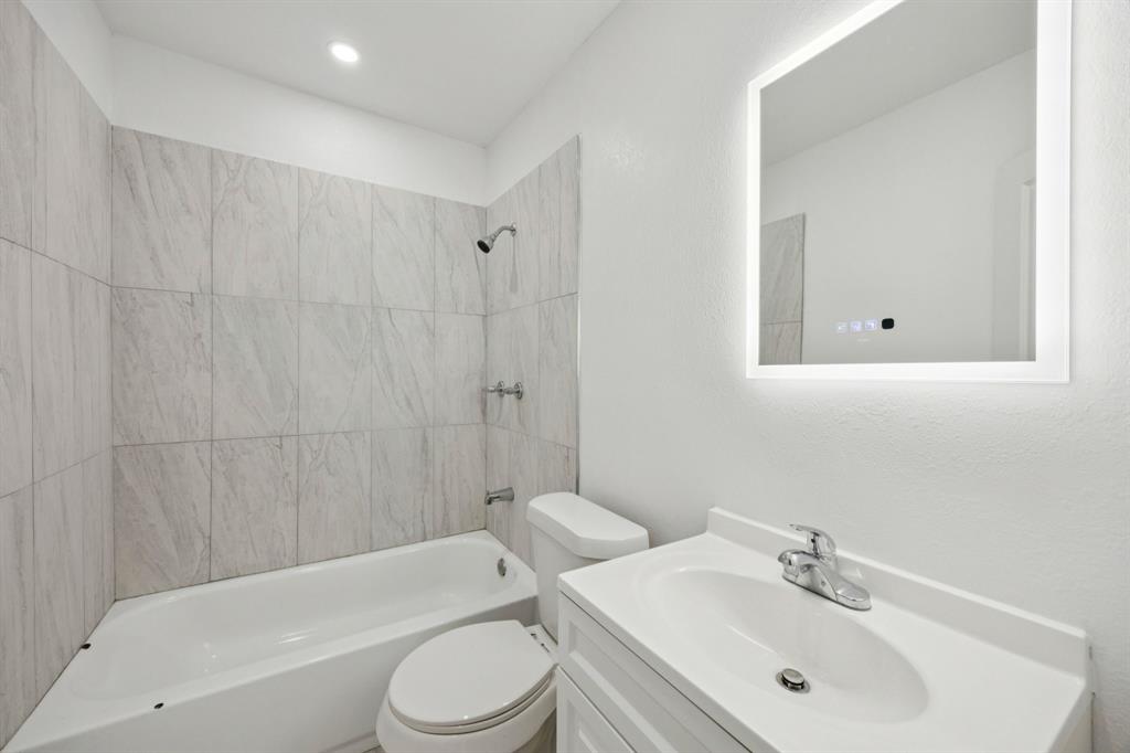 3228 Emmett Street Dallas, TX 75211 - Photo 10 of 25 a bathroom with a toilet a sink and bathtub