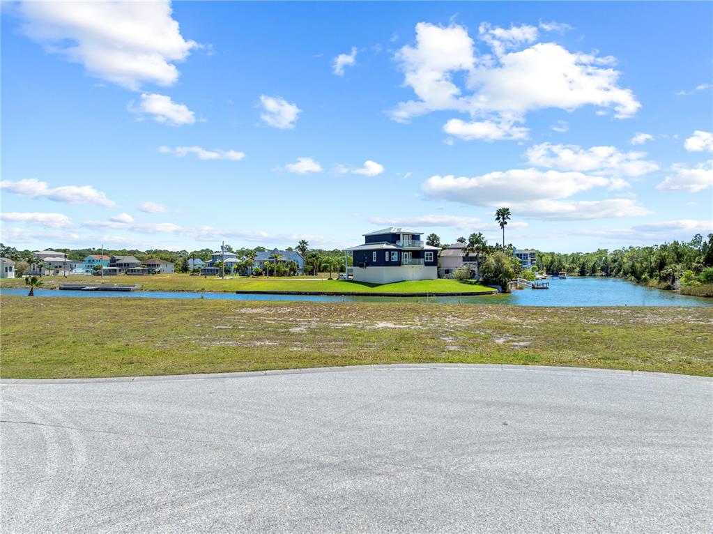 3336 Croaker Drive, Unit LOT 36 Hernando Beach, FL 34607 - Photo 17 of 20 a view of a lake with houses in the back