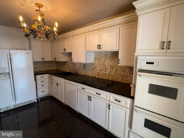 a kitchen with white cabinets stainless steel appliances and sink