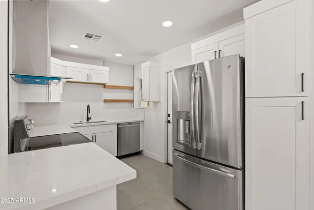 a kitchen with stainless steel appliances a refrigerator and a stove top oven