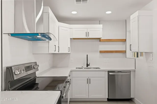 a kitchen with stainless steel appliances a sink stove and cabinets