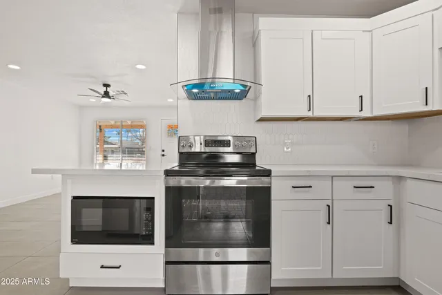 a kitchen with granite countertop white cabinets and white appliances