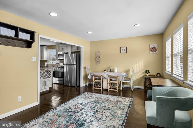 a living room with stainless steel appliances kitchen island granite countertop furniture and a rug