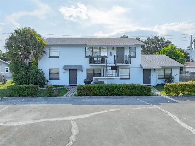 a front view of a house with a garden and plants