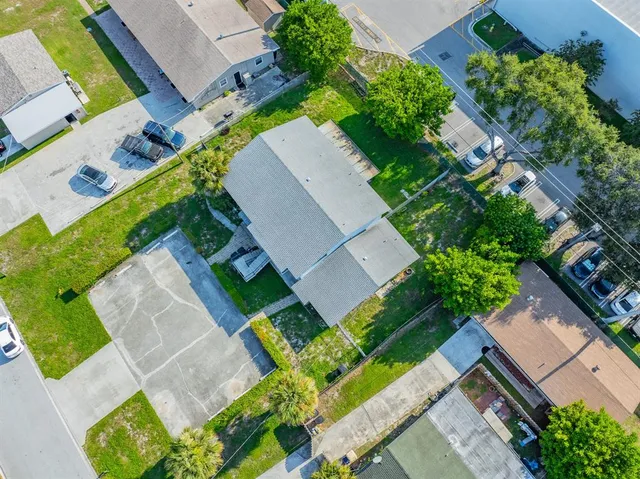 an aerial view of a house with a yard and a large tree