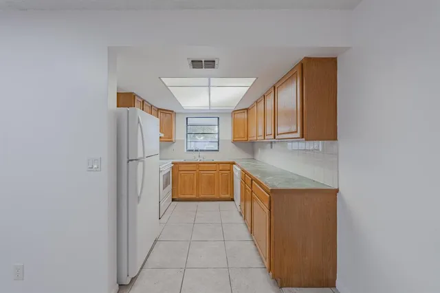 a kitchen with stainless steel appliances granite countertop a sink and a refrigerator