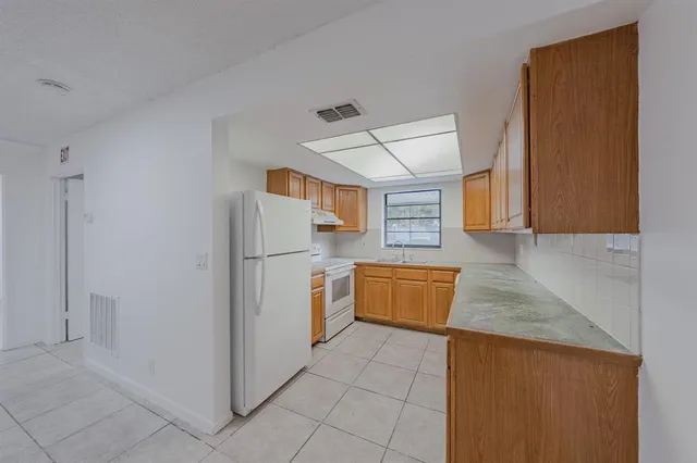 a kitchen with granite countertop a refrigerator and a sink