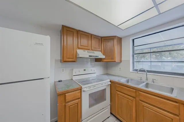 a kitchen with stainless steel appliances granite countertop white cabinets sink and a granite counter top
