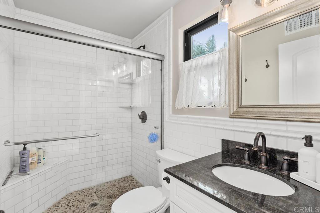 262 Chapalita Drive Encinitas, CA 92024 - Photo 17 of 30 a bathroom with a granite countertop sink toilet a mirror and shower