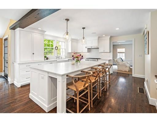 a kitchen with stainless steel appliances kitchen island granite countertop a table chairs sink and cabinets