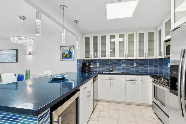 a kitchen with granite countertop a sink and white cabinets