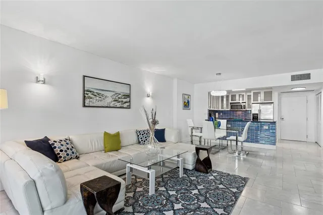 a living room with furniture and view of kitchen