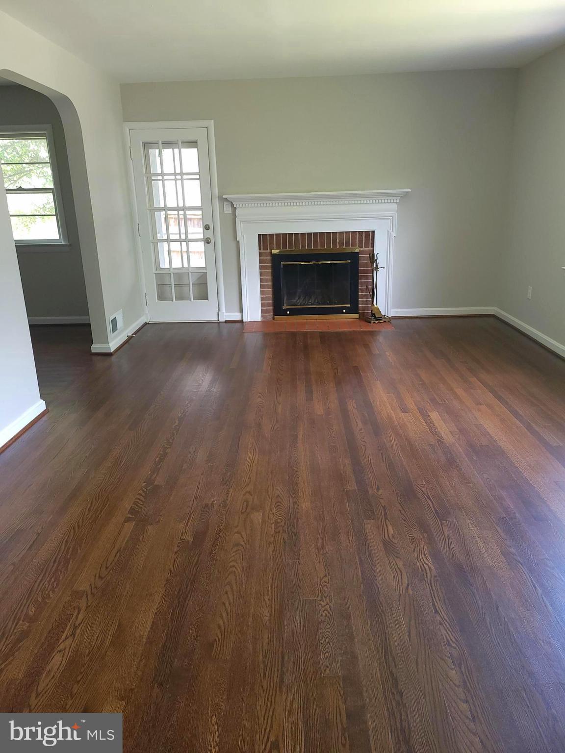 2250 North Quantico Street Arlington, VA 22205 - Photo 5 of 47 an empty room with wooden floor fireplace and windows